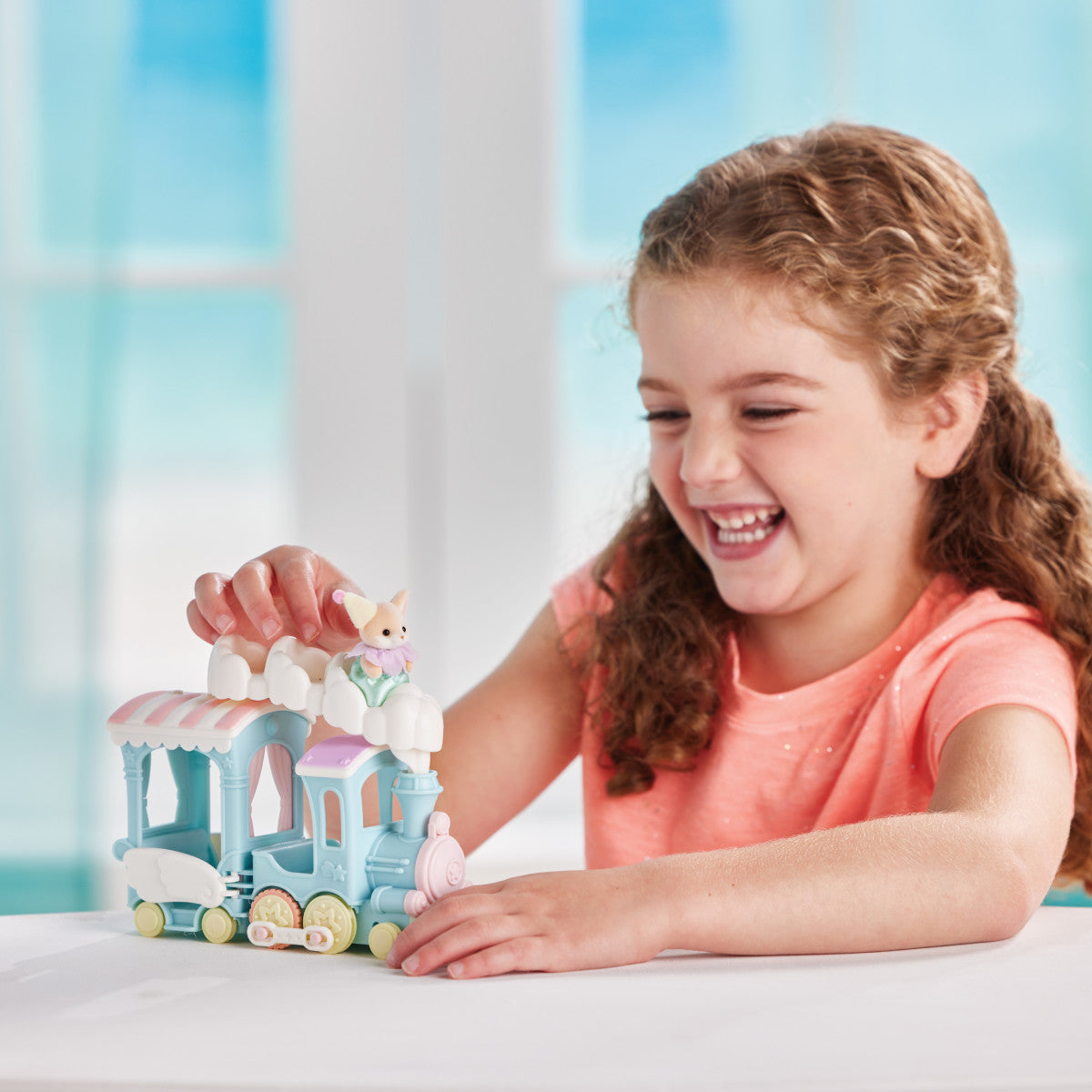 Child playing with the Floating Cloud Rainbow Train featuring pastel colors and baby Yulie Fennec Fox toy figure.