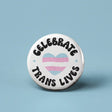 Button | Celebrate Trans Lives with a heart featuring the transgender flag colors on a white background