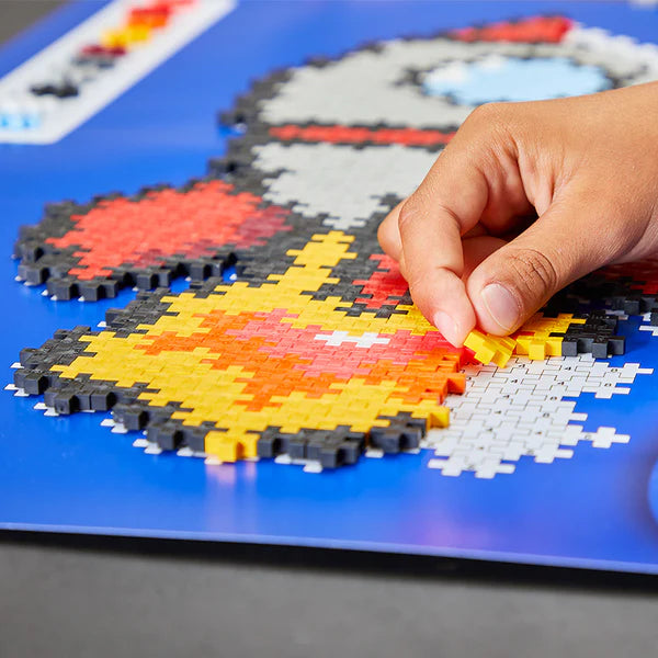 Plus Plus Puzzle by Number Rocket showing hand assembling colorful numbered pieces on a blue board.
