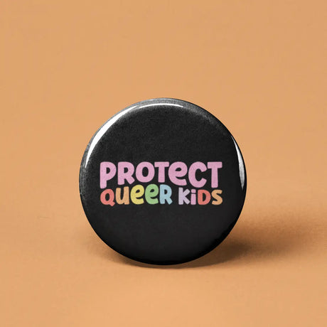 Button | Protect Queer Kids with colorful text on black background, expressing support and protection for queer children.