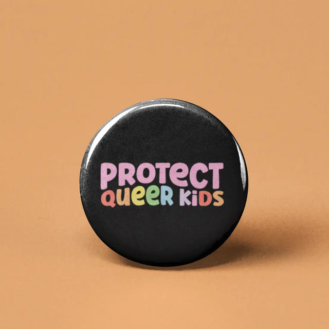 Button | Protect Queer Kids with colorful text on black background, expressing support and protection for queer children.