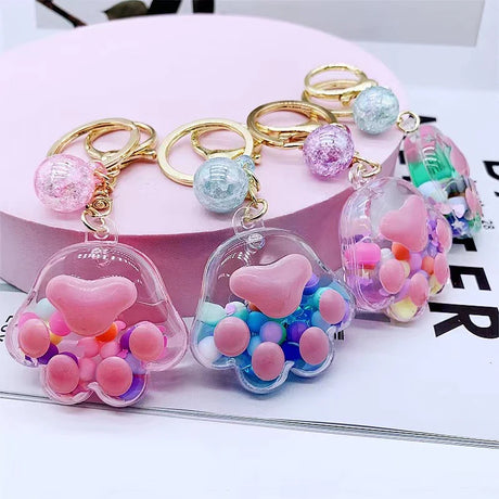 Paw Floaty KeyChain featuring colorful floating beads inside paw-shaped clear charm with keyring and clip attachment.