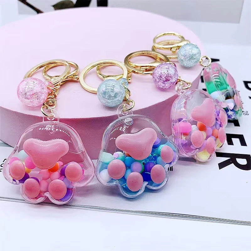 Paw Floaty KeyChain featuring colorful floating beads inside paw-shaped clear charm with keyring and clip attachment.