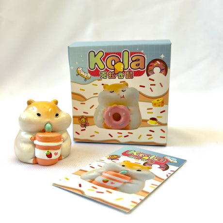 Hamster Figurine Blind Box with a cute hamster holding a drink beside its colorful packaging and insert card.