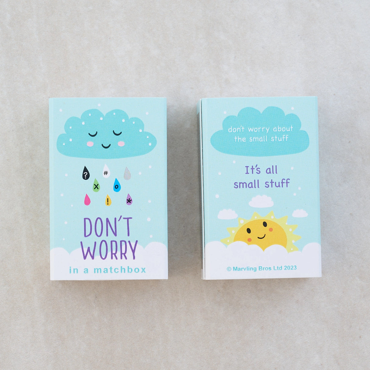 Don’t Worry Doll Matchbox showing cute cloud and sun designs with comforting messages on a pastel blue background.