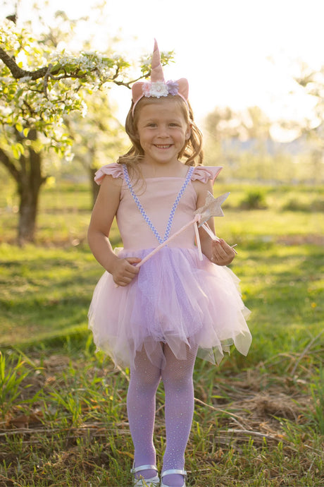 Pink Shimmer Unicorn Dress & Headband size 5-6 worn by smiling girl outdoors with wand and floral unicorn headband.