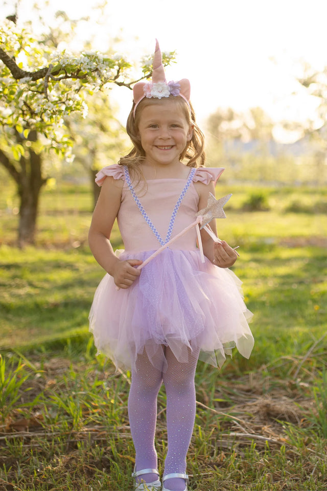 Pink Shimmer Unicorn Dress & Headband size 5-6 worn by smiling girl outdoors with wand and floral unicorn headband.