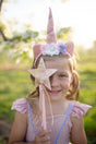 Deluxe Sparkle Star Wand held by smiling girl in pink unicorn costume outdoors in soft sunlight.