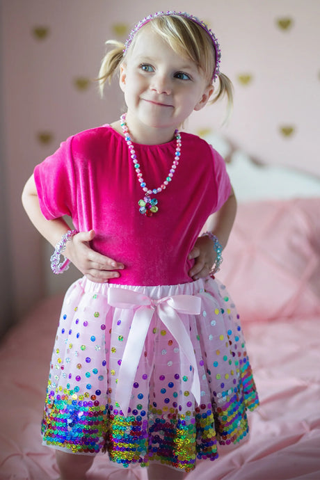 Little girl wearing a pink top and Sequins Skirt | Party Fun Size Multi with colorful rainbow sequins and bow detail.