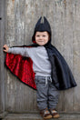 Baby Spider Bat Reversible Cape Size 2-3 shown worn by toddler with black bat side out and red spider web inside.