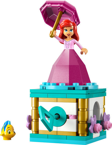 Disney Princess Twirling Ariel figure in a pink diamond dress twirling on a decorated stand with Flounder nearby.