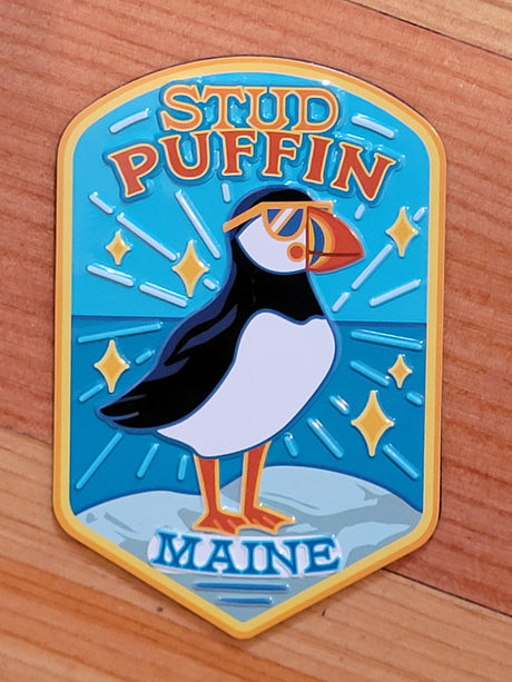 Maine Stud Puffin Magnet featuring a quirky puffin with sunglasses on a blue ocean background, perfect for fridge decor.