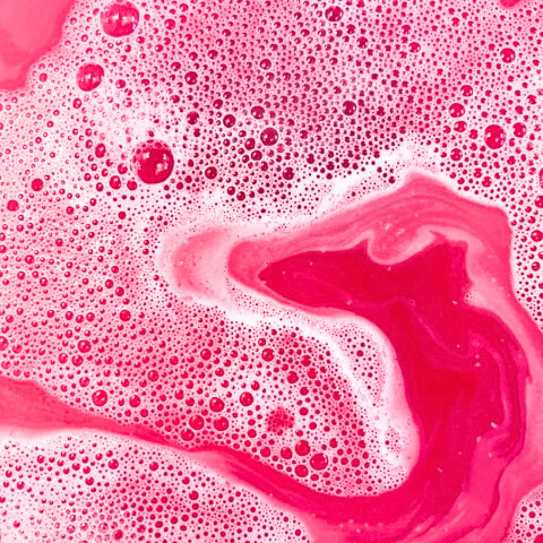 Close-up of vibrant pink foaming bubbles created by Little Whale Bath Co Bubble Bath in water.