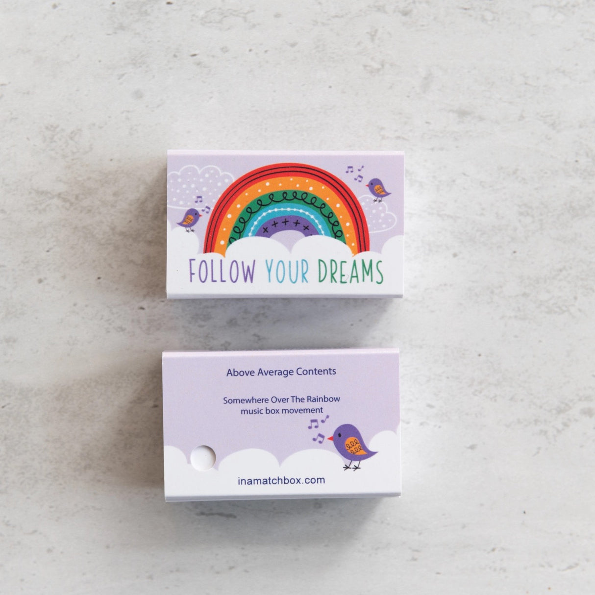 Somewhere Over the Rainbow Musicbox Matchbook with colorful rainbow and "Follow Your Dreams" message on a light purple background.