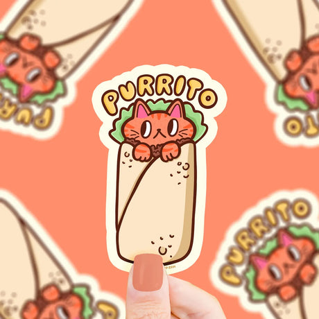 Close-up of a hand holding a Purrito Kitty Sticker featuring a cute cat wrapped in a burrito design on vinyl.