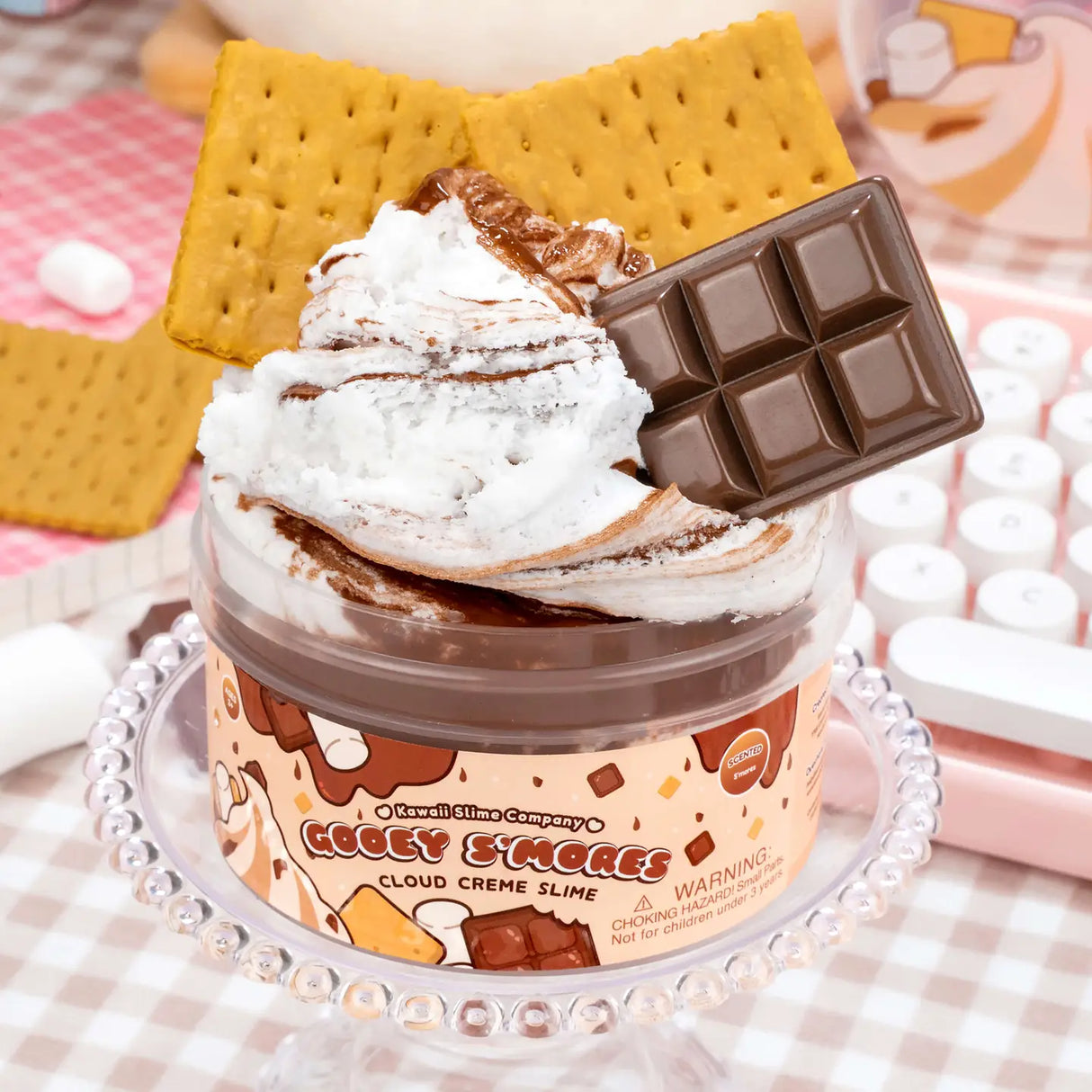 Gooey S'mores Cloud Cream Slime with chocolate and marshmallow swirl, topped with graham cracker and chocolate bar charms.