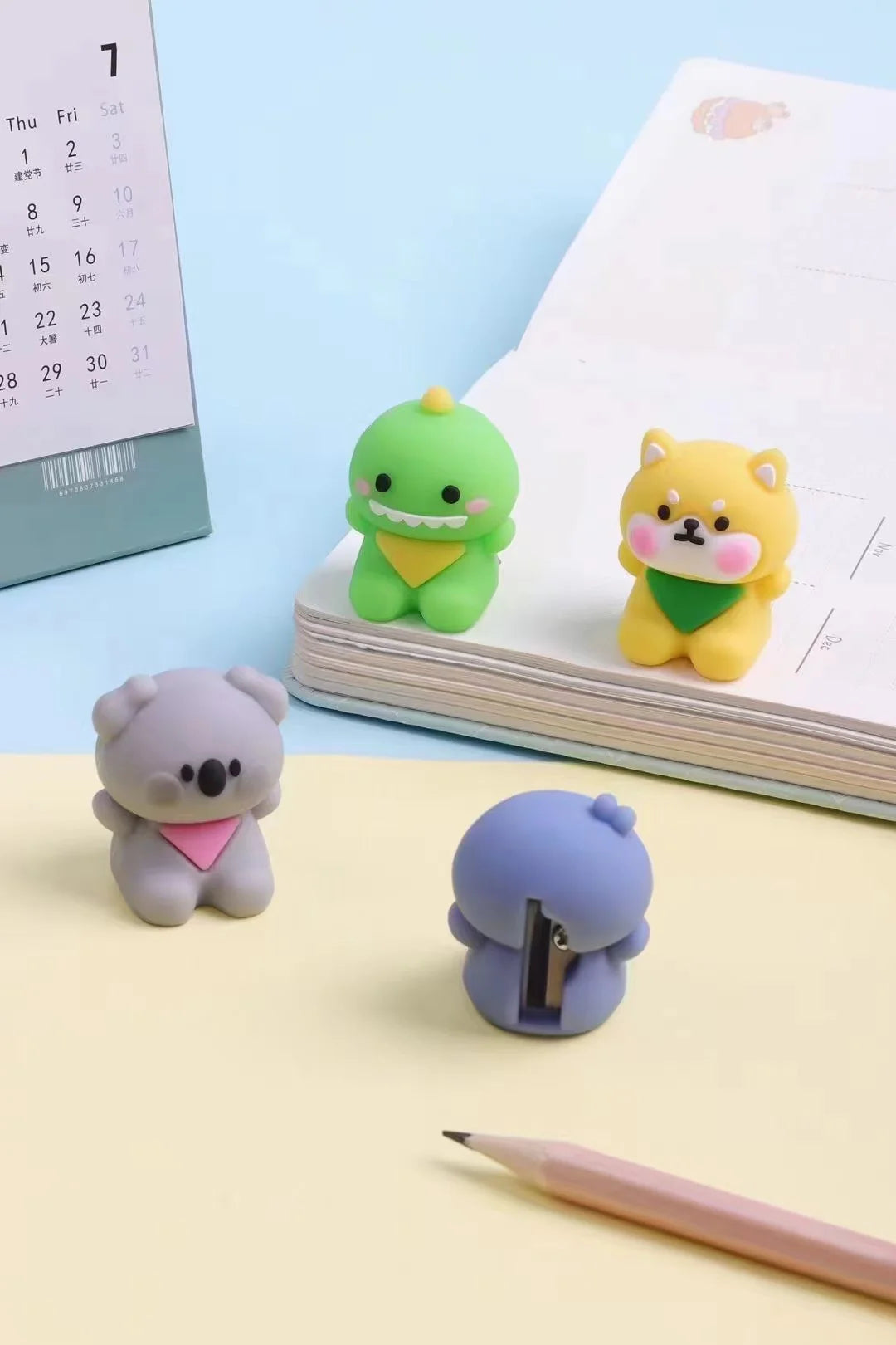 Lovely Animal Pencil Sharpener set featuring cute green dinosaur, yellow dog, gray koala, and purple bear designs on desk.