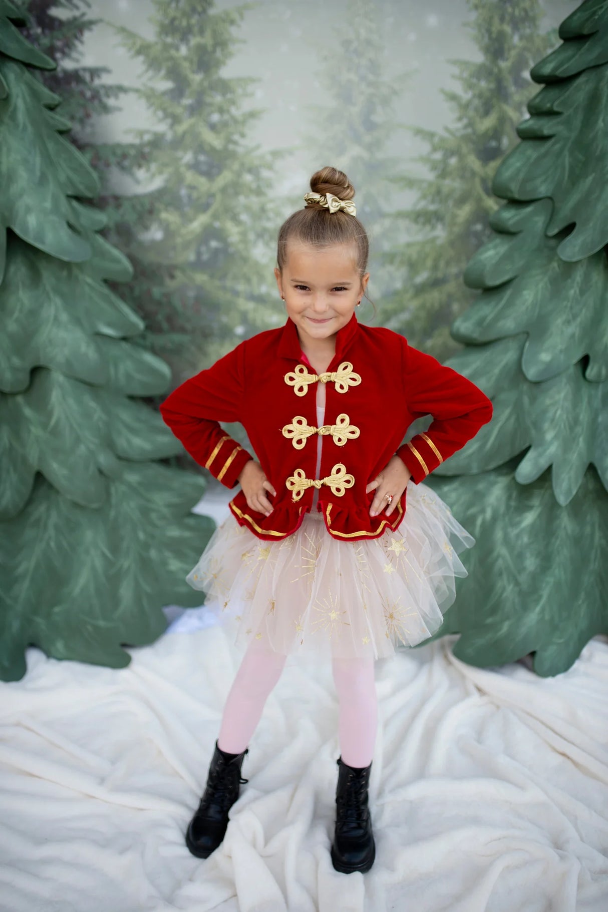 Young girl wearing Sparkle Star Tutu size 4-6 with white tulle and gold stars, smiling confidently in festive setting.