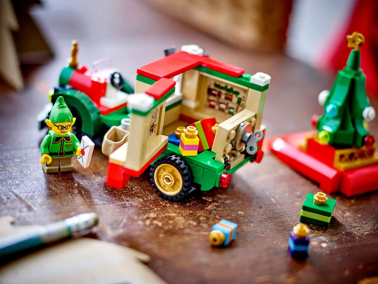 LEGO Santa's Delivery Truck playset with elf minifigure, presents, mini tree, and festive holiday details on table.