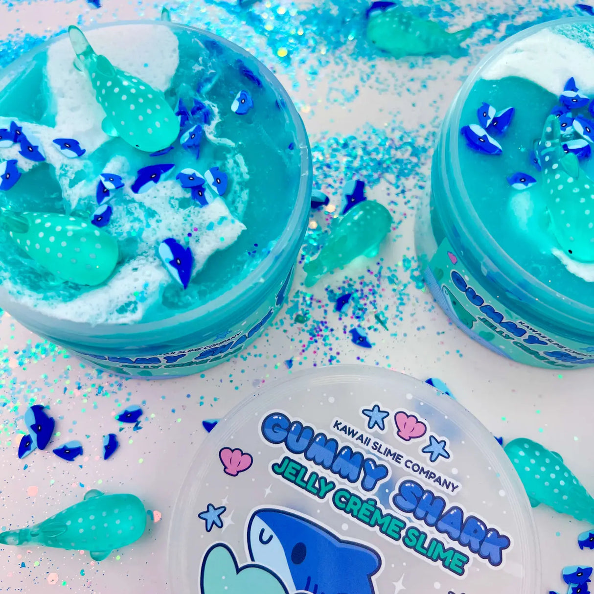 Gummy Shark Jelly Creme Slime with blue ocean color, shark fimo slices, white swirls, and whale shark charms.