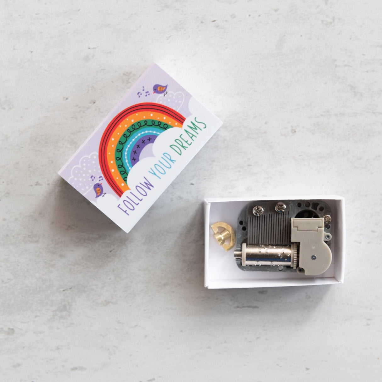 Somewhere Over the Rainbow Musicbox Matchbook with "Follow Your Dreams" design and miniature music box components inside.