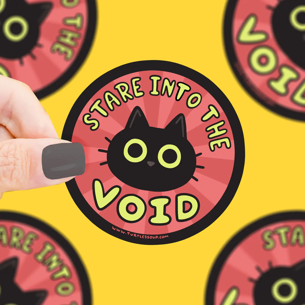 Hand holding Stare Into the Void Sticker featuring a black cat on red background, durable vinyl, weatherproof design.
