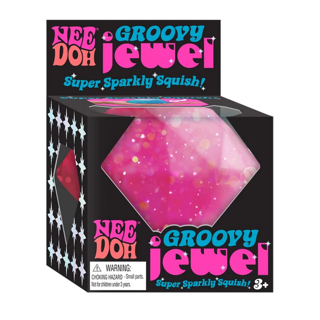Bright pink glittery squishy jewel toy in black packaging labeled Nee Doh Groovy Jewel for kids ages three and up