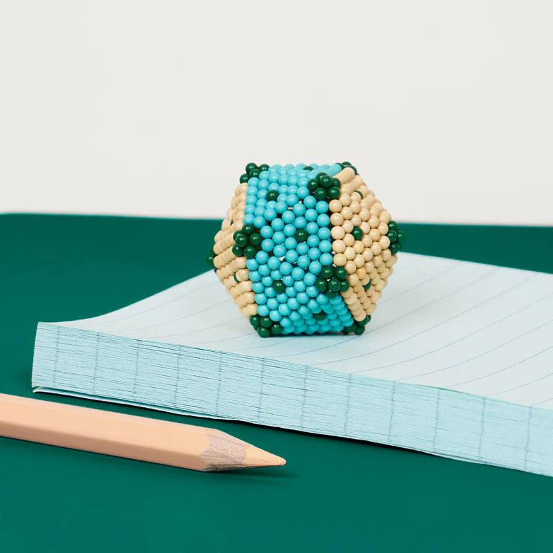 Speks. Bolds. Moxie magnetic balls shaped into a colorful matte geometric form on a notebook.