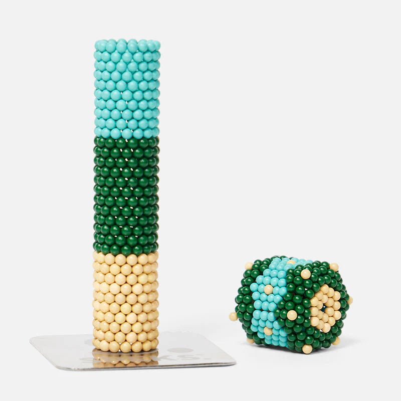 Speks. Bolds. Moxie colorful matte magnetic balls stacked and shaped creatively on a white background.