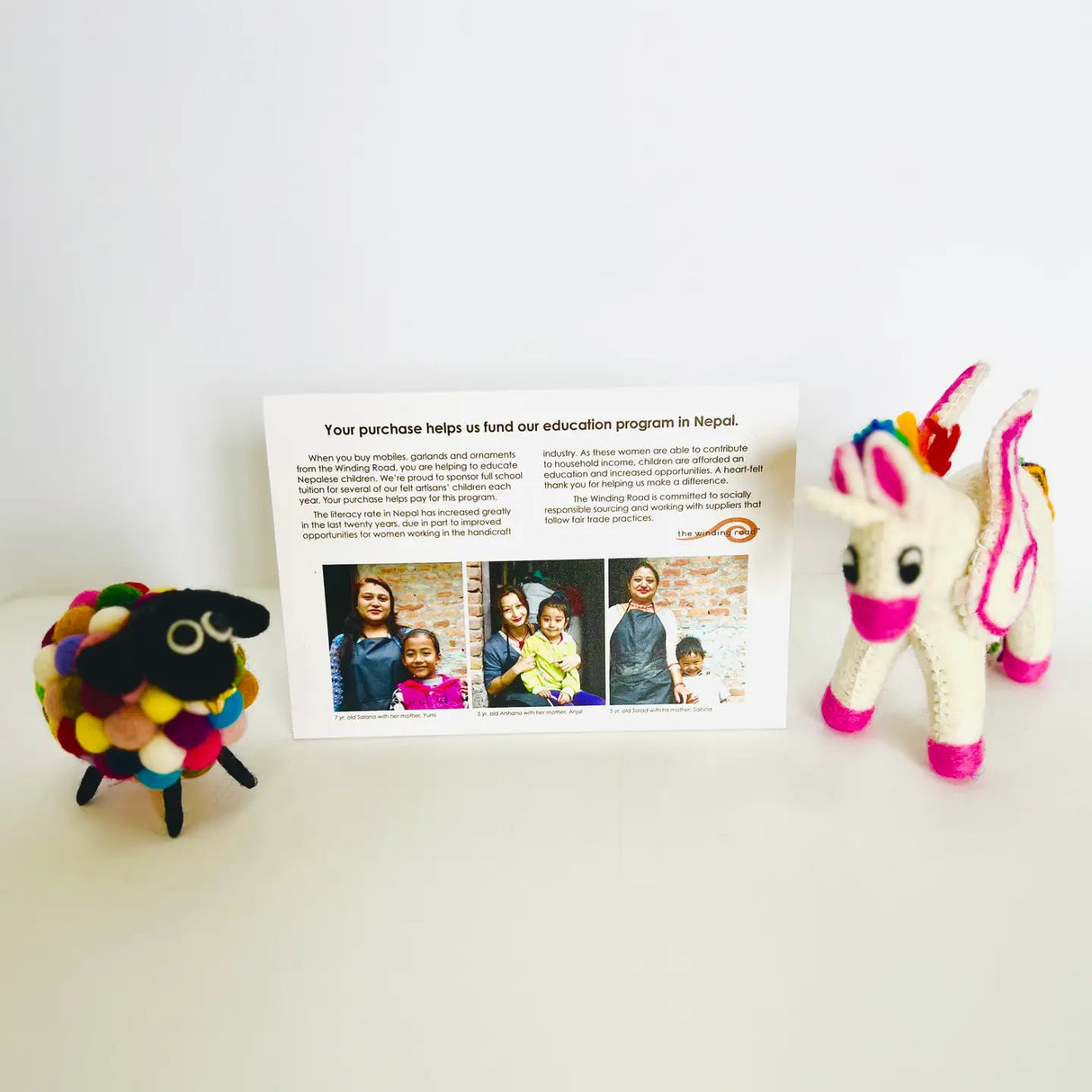 Felt Mobile | Sheep showing colorful wool sheep and white felt unicorn with fundraising card behind.