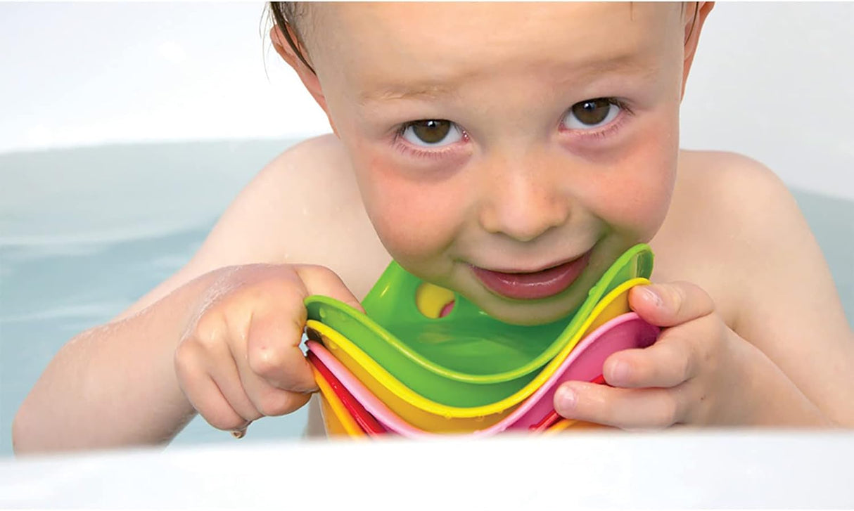 Child playing with colorful stacking Bilibo Mini toys in water, encouraging creativity and motor skills development.