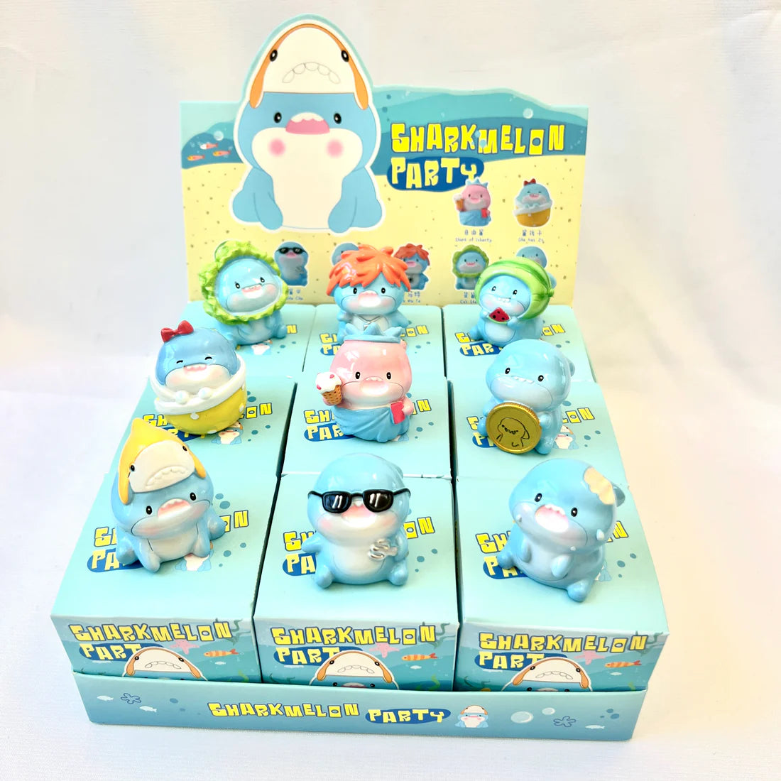 Shark Figurine Blind Box with assorted cute shark resin figures displayed in colorful packaging for ages 3 and up.