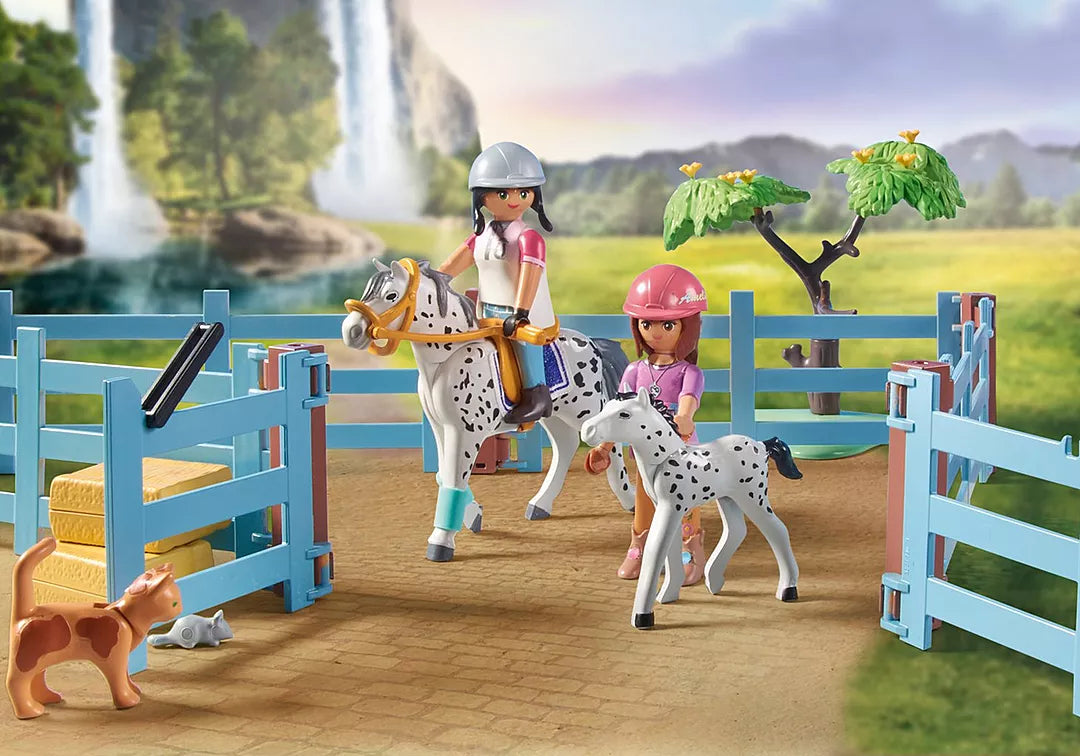 Horses of Waterfall | Waterfall Ranch featuring riders, spotted horses, fenced paddock, and waterfall backdrop.
