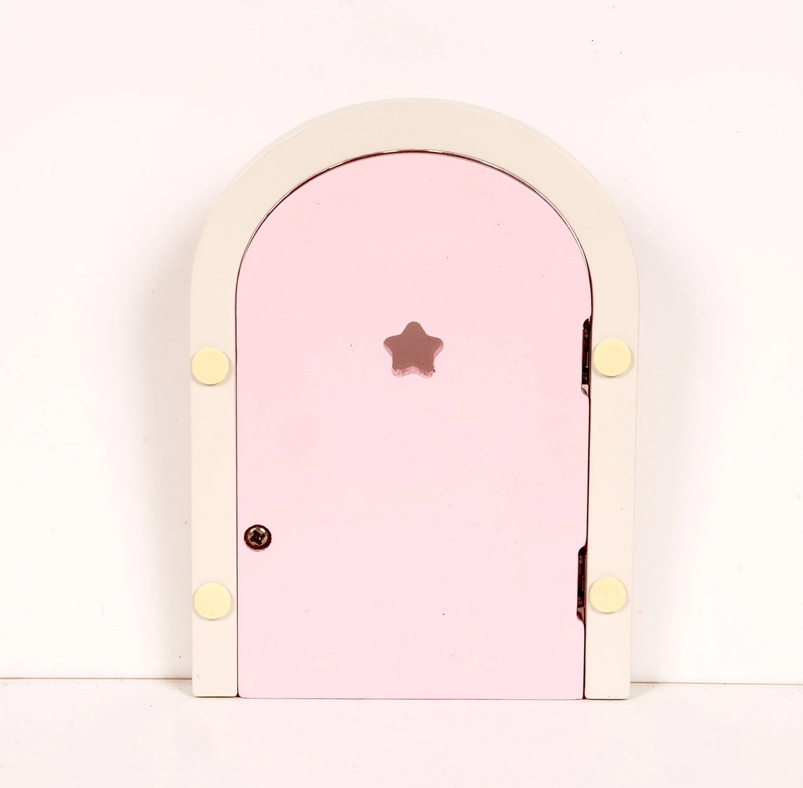 Small wooden fairy door with pale pink panel and star-shaped cutout on white background