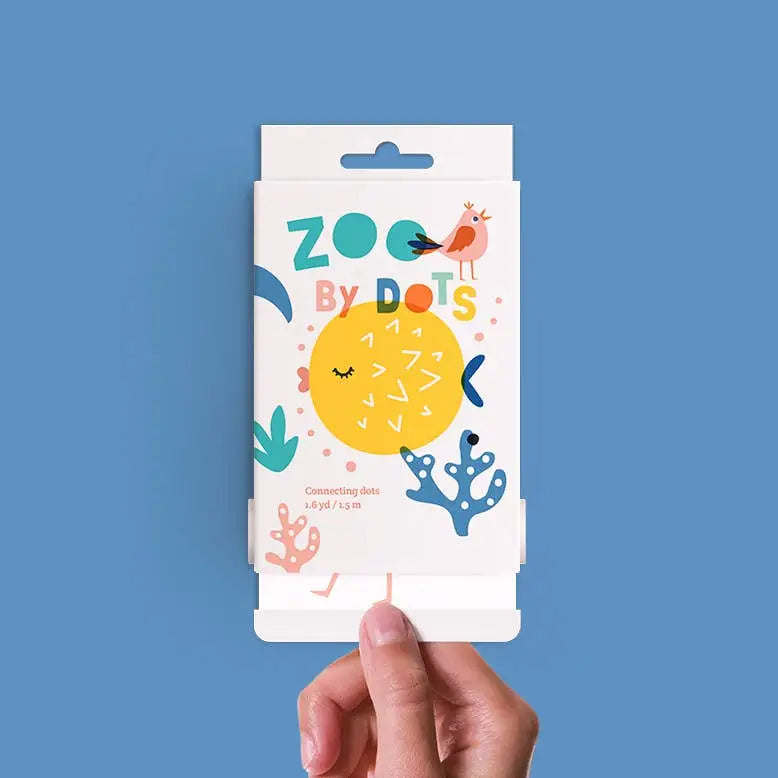 Hand holding Scrollino Coloring Book & Dot to Dot | Zoo showing animal dot-to-dot activity on white biodegradable packaging.