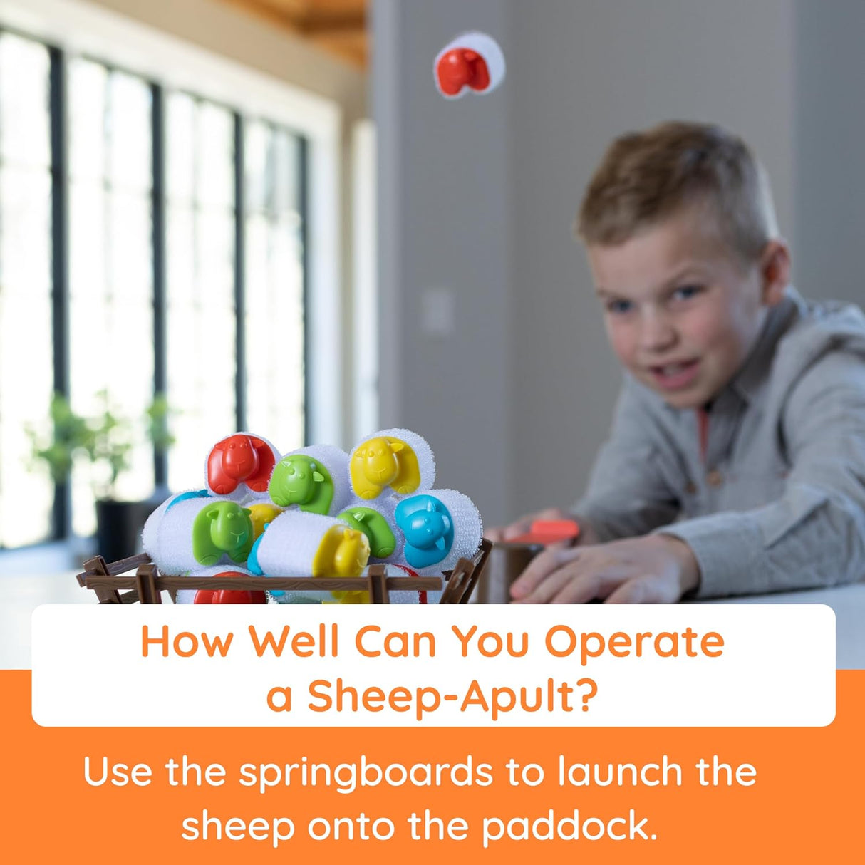 Child playing Heap-O-Sheep launching colorful sheep with a springboard onto the hook-and-loop paddock.