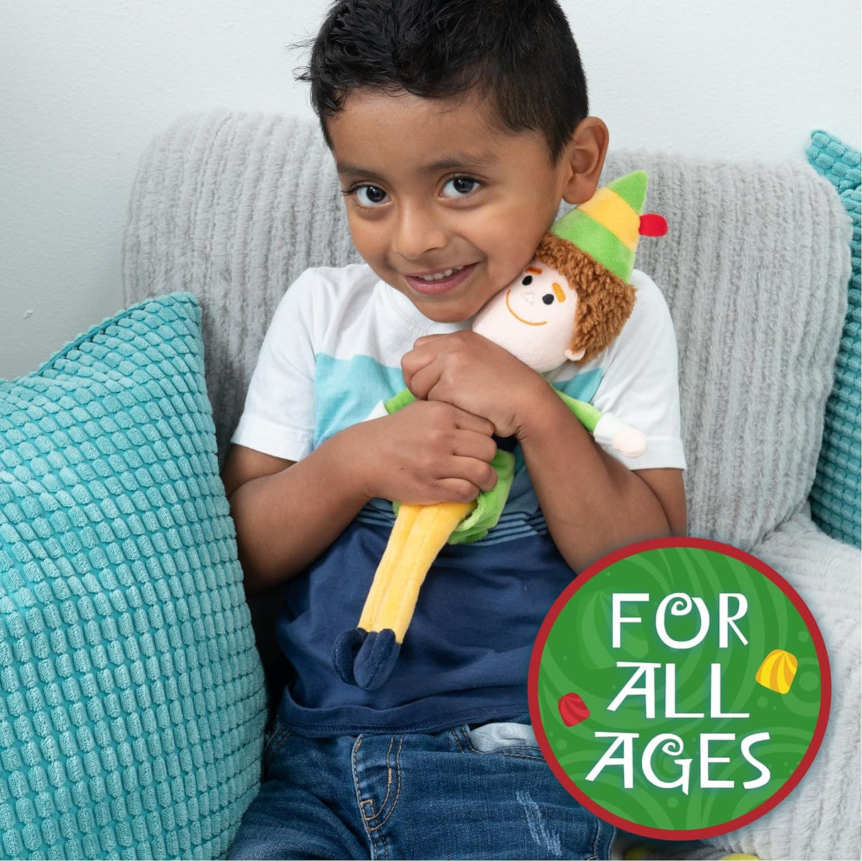 Buddy the Elf | Small plush held by a smiling child sitting on a couch with blue cushions.