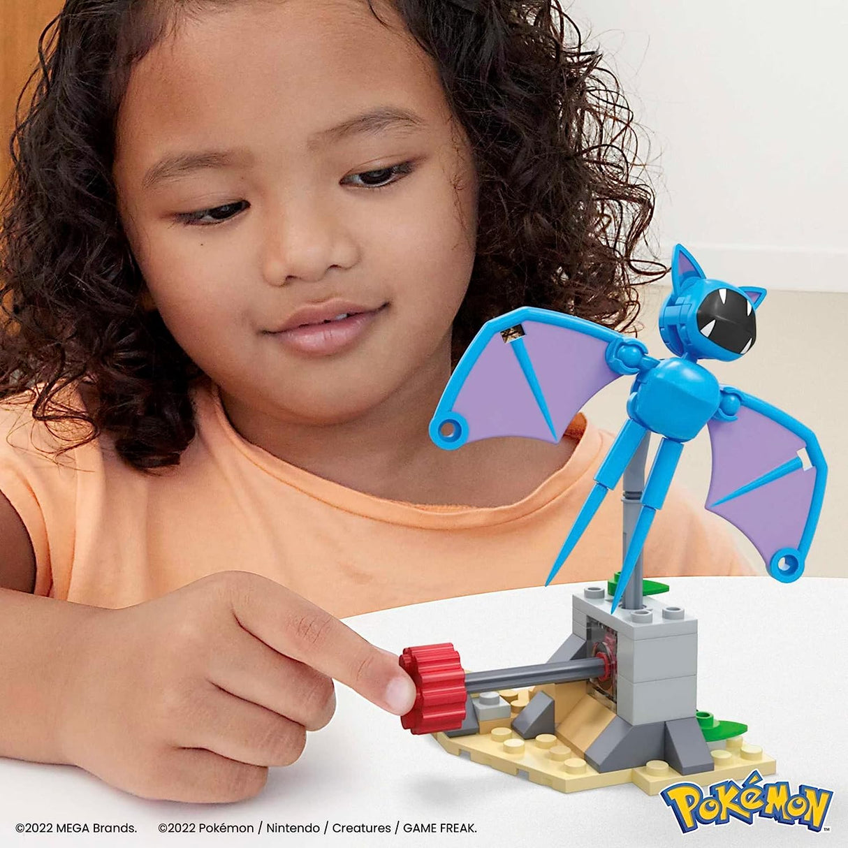 Child playing with Mega Construx Pokemon Zubat building set featuring motion-activated flying Zubat figure.
