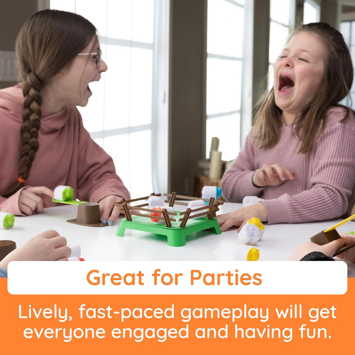 Two children laughing and playing the Heap-O-Sheep game with springboards and a hook-and-loop paddock.