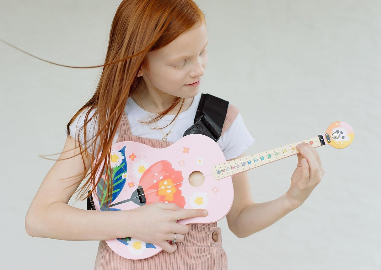 Child playing the TinkerTar | Pink Floral Acoustic 1-string guitar designed for young beginners learning music.