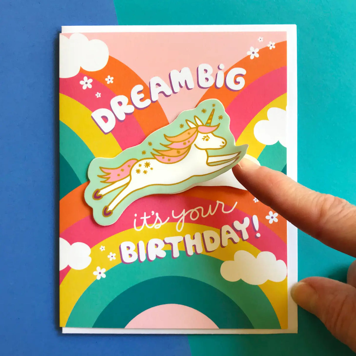 Dream Big Unicorn Sticker Birthday Card with colorful rainbow design and removable vinyl unicorn sticker on blue background.