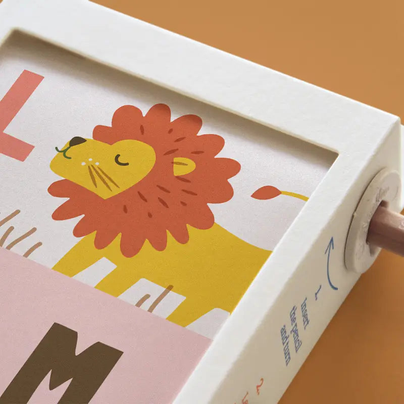Close-up of Scrollino ABC Learning Book showing a lion illustration and wooden pencil for fine motor skill development.