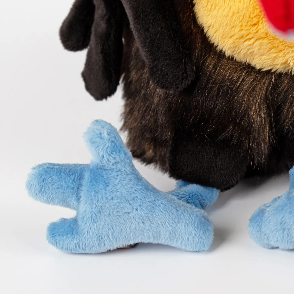 Chakka Tukan Toucan plush toy showing soft blue feet and part of its furry body close-up.