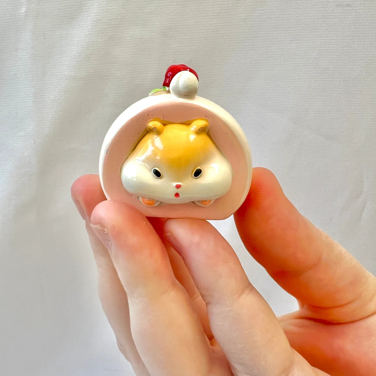 Hand holding a cute yellow hamster figurine from the Hamster Figurine Blind Box collection.