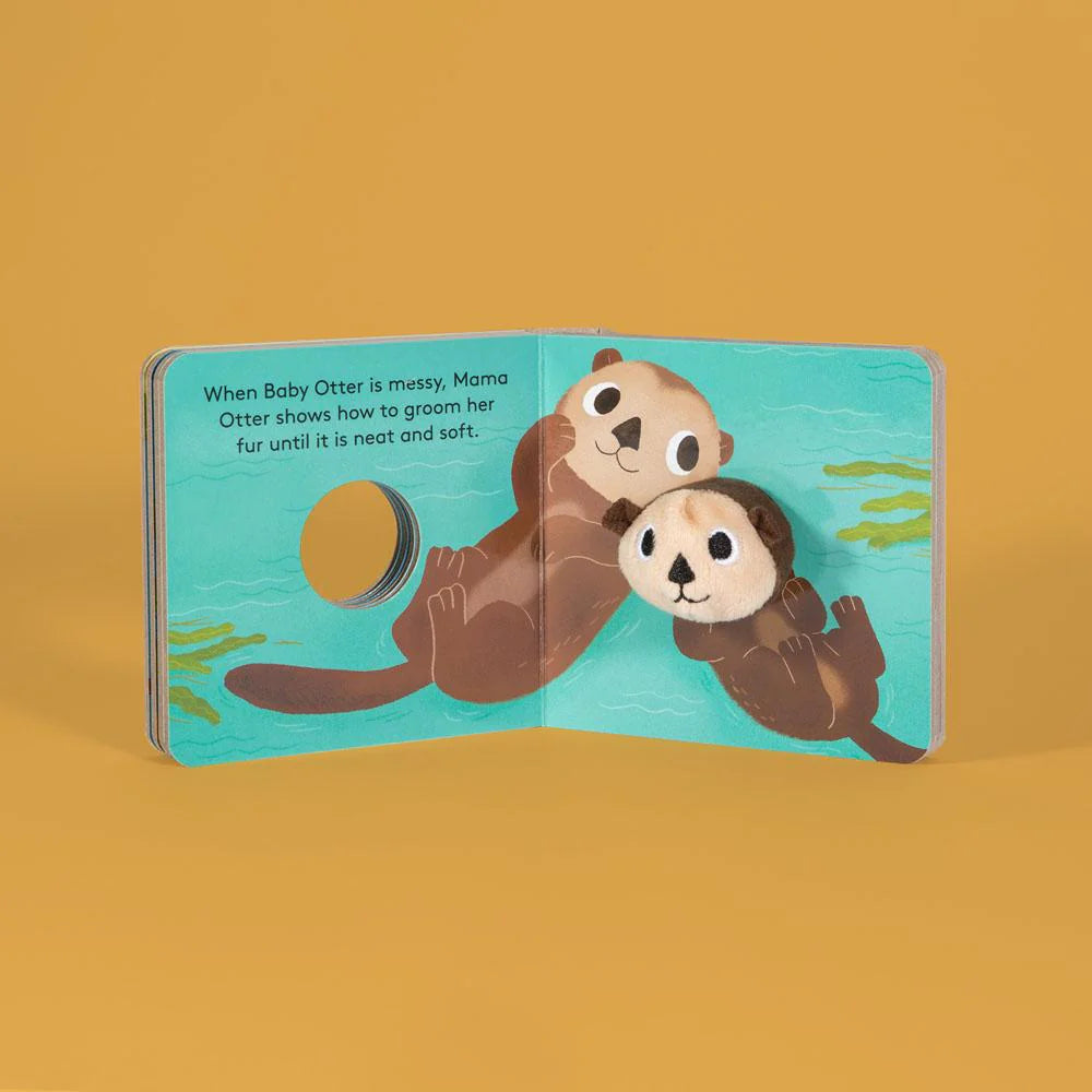 Baby Otter with Finger Puppet board book open to a playful otter scene with a soft plush finger puppet attached.