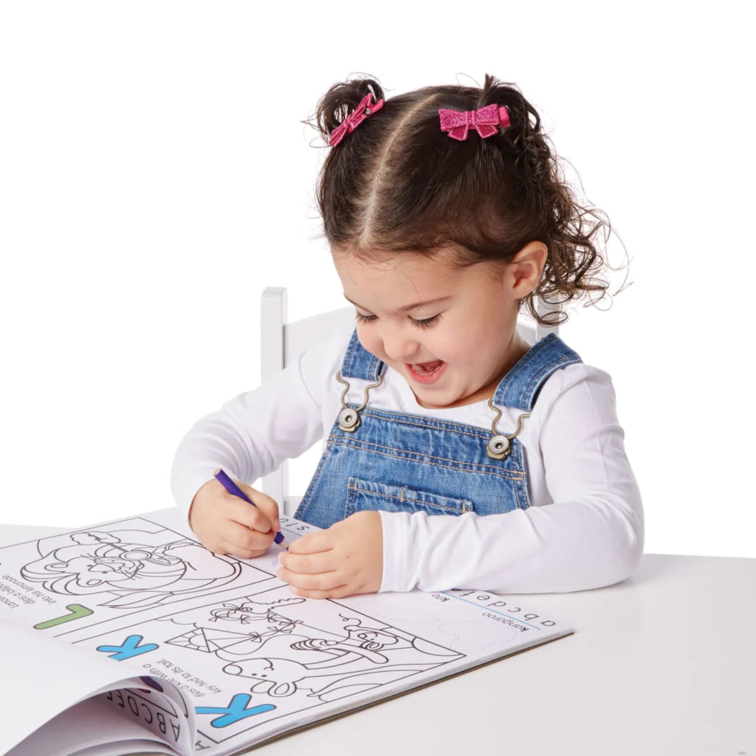 Young girl coloring in the Alphabet Activity Pad with letter-themed pictures and tracing activities for kids ages 4 and up.