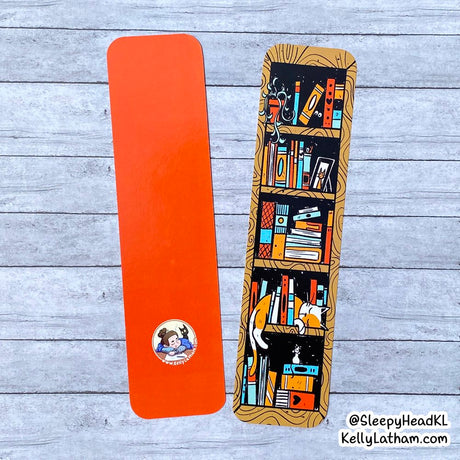 Bookshelf Bookmark featuring a colorful bookshelf design with a cozy cat printed on high gloss paper.