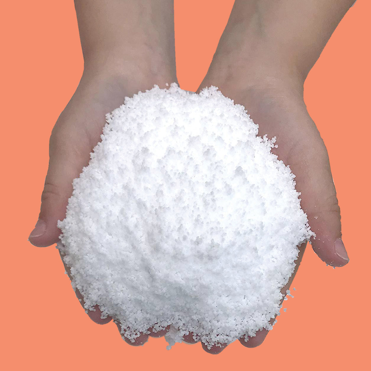 Hands holding a fluffy pile of Instant Winter Snow, a cool, water-absorbing faux snow for indoor winter fun.