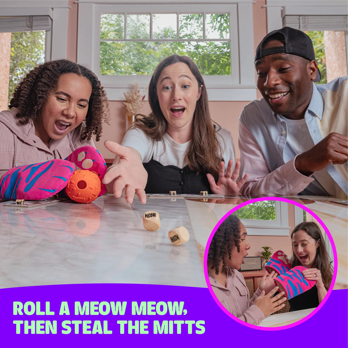 Three friends excitedly play The Cat Mitt Game rolling dice and reaching for colorful mitts during game night.