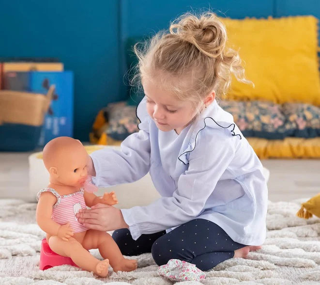 Child playing with Drink & Wet Emma doll using potty and refillable bottle for imaginative play and potty training.